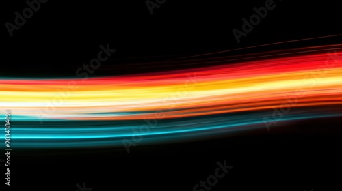 Colorful light streaks create a scene of movement and energy in the dark