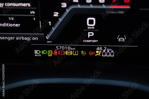 Many different car dashboard lights with warning lamps illuminated. Light symbol that pops up on dashboard when something goes wrong with the engine. Close up shot of hybrid car instrument panel