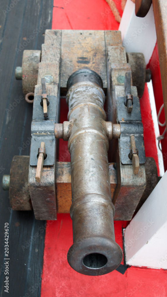 Obraz premium Vintage cannon on ship. An old cast iron cannon on the deck of a sailing ship, top down view.