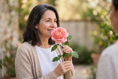 Konzeptbild zur Redewendung „etwas durch die Blume sagen“, bei dem eine Person wortwörtlich durch eine Blume spricht.