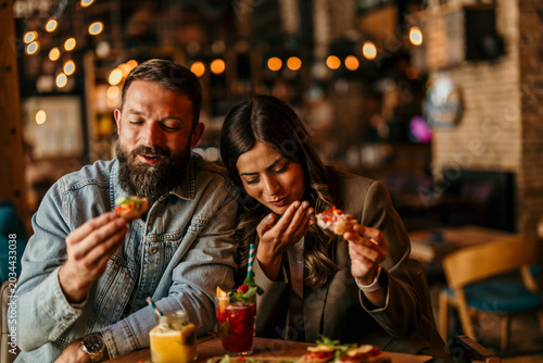 Foto Couple enjoying appetizers and cocktails at a restaurant
