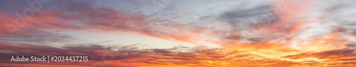 Panoramic sunset sky with orange clouds and dramatic twilight horizon background