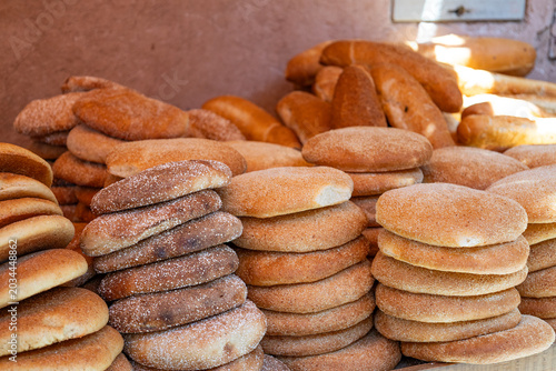 Stacks of freshly baked traditional Moroccan flatbread khobz at a street market