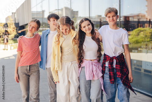 Tableau sur toile Diverse group of smiling happy teen boys and girls walking together on the stree
