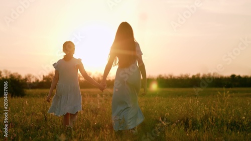 Fotografija People nature, woman with teenage child holding hands walking towards sunset, gi