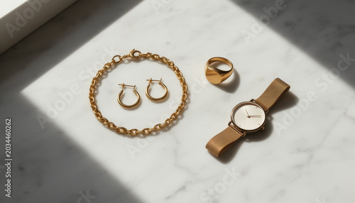 Gold jewelry set on marble surface with natural light
