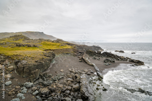 Rocky volcanic shoreline with moss covered cliffs