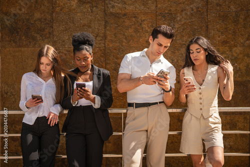 Photos Young adults concentrating on smart phones displaying digital addiction