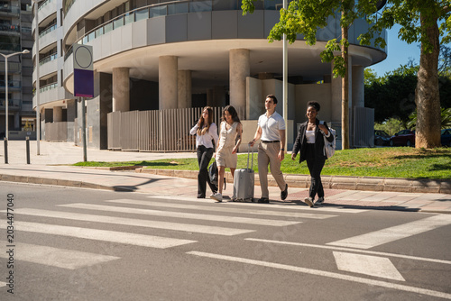 Schilderij op canvas Diverse friends traveling across city crosswalk with luggage
