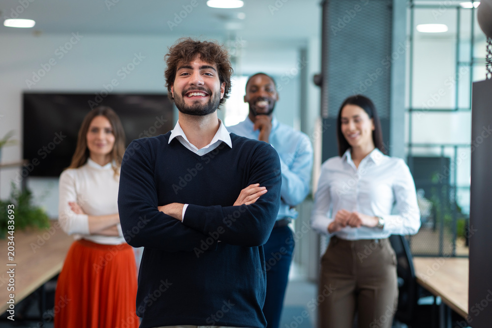 Obraz premium Confident business leader standing with diverse team in office