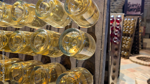 Tableau sur toile Wine bottles resting on their sides within wooden racks as part of the riddling