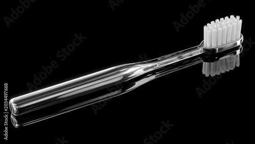 A transparent toothbrush with white bristles, designed for daily oral hygiene, rests on a reflective black surface.