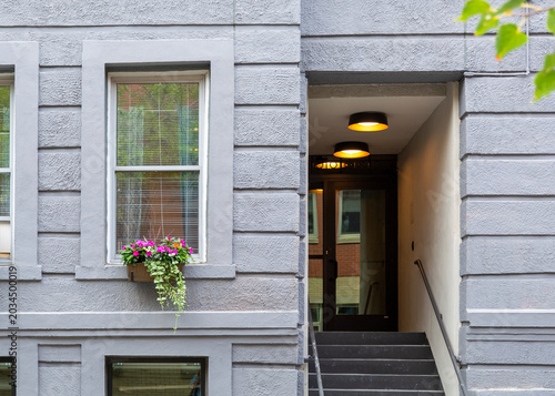 Φωτογραφία Entrance to a classic residential apartment building with gray stucco facade and