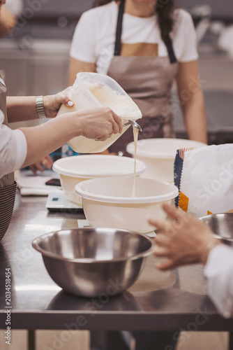 Bakers prepare sourdough dough at a cooking class in a kitchen during a weekend workshop for bread making and pizza making activities