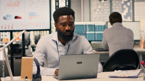 Foto Businessman working in modern office analyzing business intel and KPI metrics, visual data, charts and forecasting reports supporting organizational planning and professional workflow