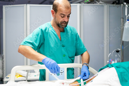Quadro su tela Doctor adjusting iv tubing for patient in hospital bed