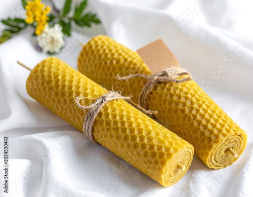 Natural Beeswax Candles Tied with Twine on White Fabric Background