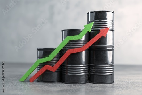 Close-up view of black metal barrels with graph arrows for business concept