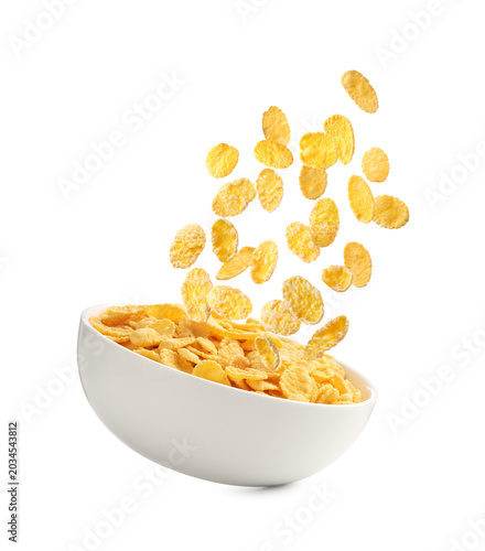 Fotografie Corn flakes and bowl in air against white background