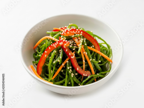 Healthy green seaweed kelp salad in portion isolated on white background for traditional Asian chuka food concepts
