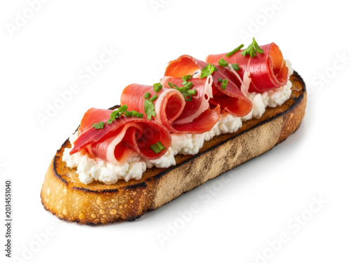 Crunchy toast with fresh white goat cheese and savory smoked serrano ham isolated on white background for snack