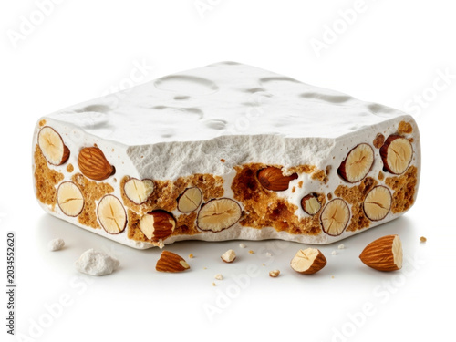 Broken piece of traditional Italian sweet torrone white nougat with nuts isolated on white background for holiday