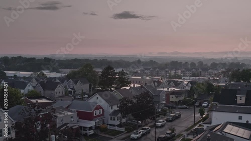 real-time aerial view over a quiet New Jersey residential neighborhood featuring family homes and quiet streets under a moody, overcast twilight sky town of East Rutherford