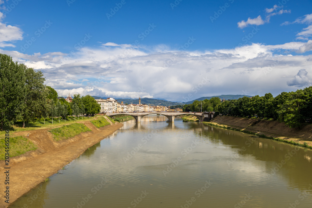 Fototapeta premium Arno River View with Historic Florence Buildings and Blue Sky