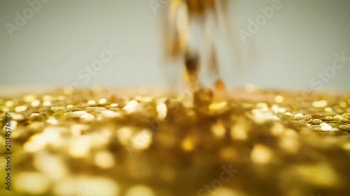 low-angle macro video of vibrant golden glitter, with a smooth push-in revealing texture, dreamlike bokeh, and clean copy space above. Luxury product advertising concept