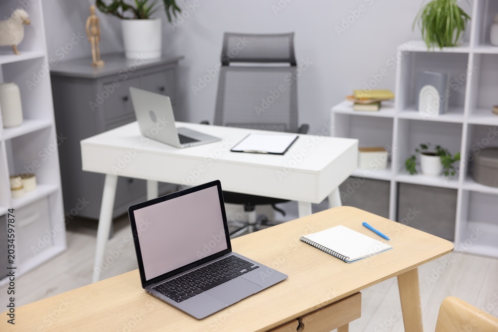 Fototapeta premium Desks with laptops, stationery, other furniture and decor. Interior design
