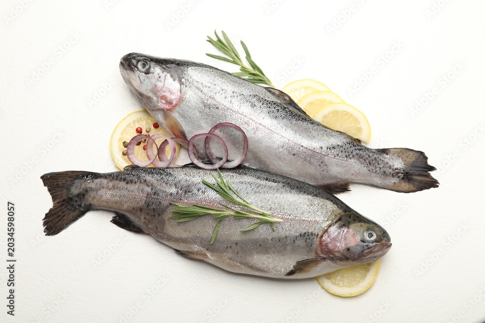 Obraz premium Raw trout fish and spices on white table, flat lay