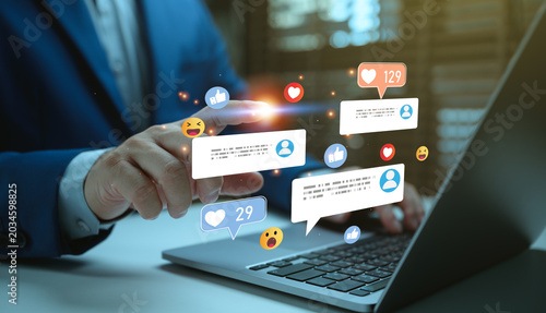 Businessman using laptop with social media engagement interface, online customer communication and digital marketing notifications for audience interaction and brand promotion.