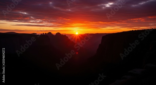 Fiery Sunrise Over Mountainous Canyon Landscape
