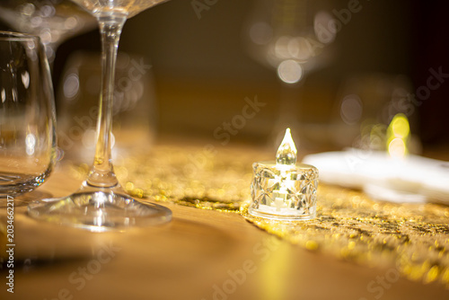 Luxury restaurant table setting with wine glasses, warm bokeh lights, and elegant decoration. Sophisticated dining atmosphere ideal for concepts of fine dining, celebration, hospitality, gastronomy, a