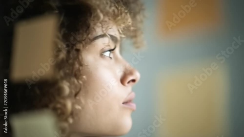 Thoughtful woman gazing out with colorful notes nearby