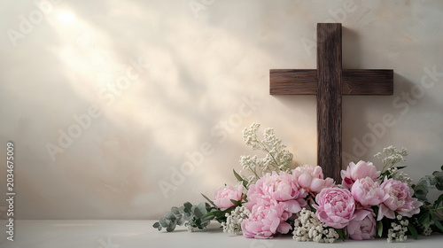 A stunning dark cross with the flowers at the background on the light background with sunlight