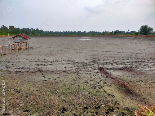 Fishing wetland temporarily drained out and covered with mud, rural area landscape view 