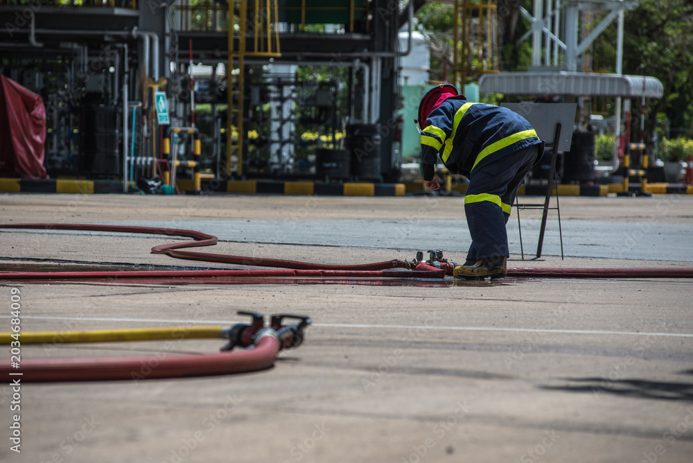 Fototapeta premium Firefighters practiced responding to fires in buildings and oil depots using water and foam.