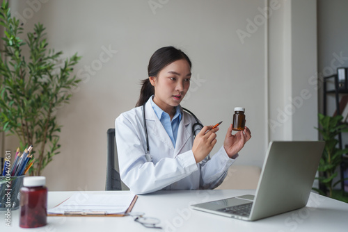Female doctor explaining medicine bottle during online consultation