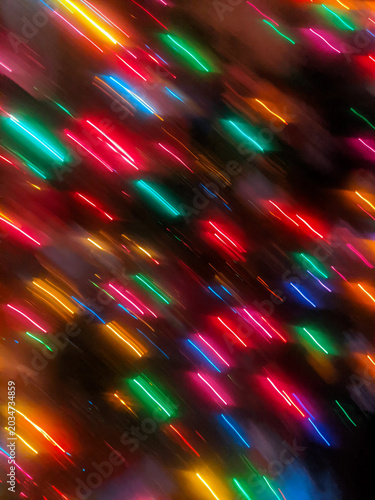 Vászonkép A dynamic, full-frame abstract intentional camera movement (ICM) shot showing vibrant red, green, blue, and gold holiday lights blurred into bright diagonal streaks against a dark background