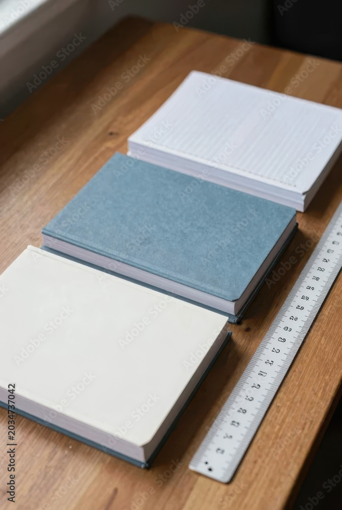 Fototapeta premium A pile of new notebooks in squares and lines, neatly stacked on desks, realistic lighting, sharp and detailed image