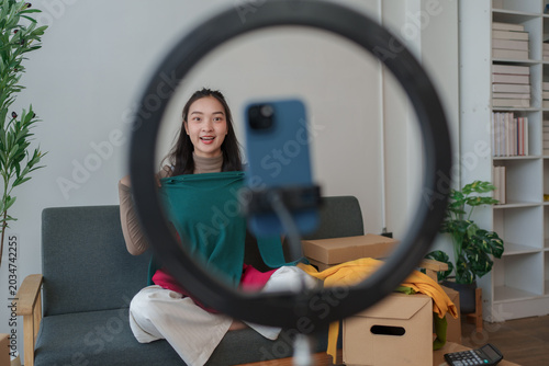 Fotografía Young woman livestreaming selling clothes online from home