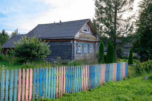A street in a village in the Yaroslavl region of Russia with a fragment of an old traditional wooden house