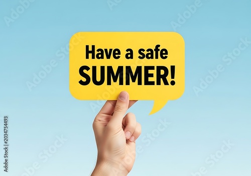 Hand holding a yellow speech bubble with the text have a safe summer