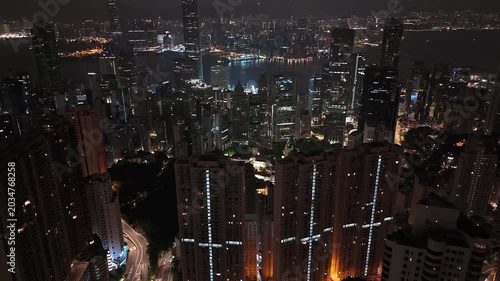Drone overview of Hong Kong skyline and Victoria Harbour at night.