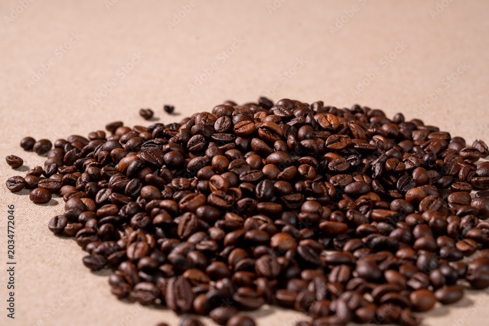 Fototapeta premium Close-up macro shot of roasted coffee beans with dark background. Fresh aromatic coffee beans with rich texture and warm tones, perfect for café, beverage.