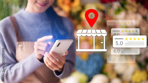 Asian women using smartphone search local business review rating location map pin icon overlay store finder app customer feedback online shopping market
