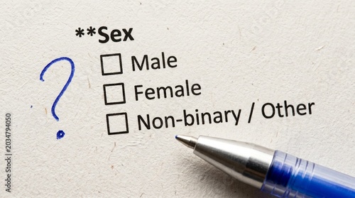 Hand writing gender identity options on checklist with blue pen on paper form