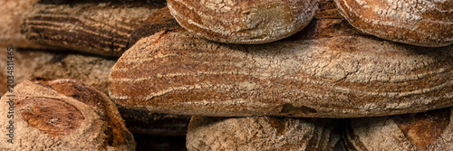 Panorama of loaves of large white sourdough bread on a bakers stall food market