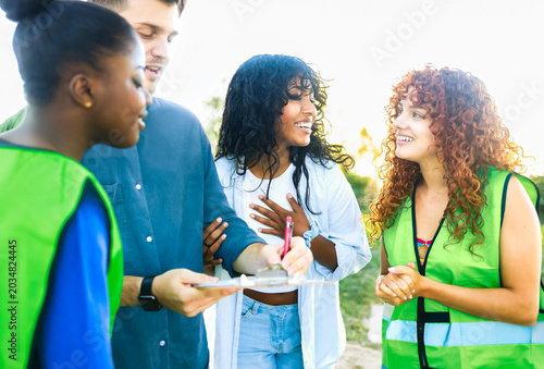 Diverse volunteers collecting signatures in public park - Community charity and social activism concept